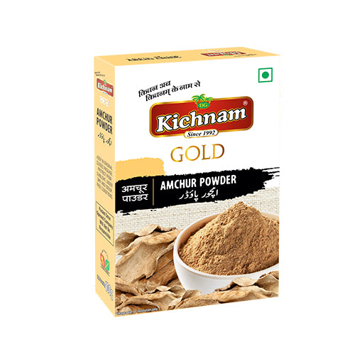Angled white and gold Kichnam Amchur Powder box with a bowl of brown powder.