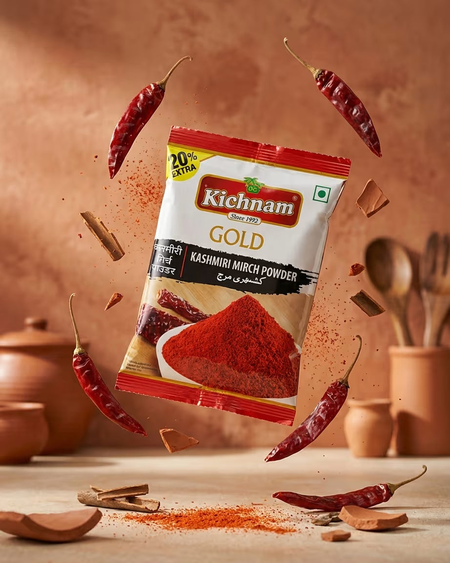 Kichnam Gold Kashmiri Mirch Powder package with red chili peppers and spices on a wooden surface.