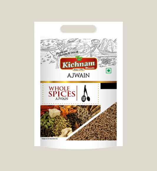 A white 100 gm pack of Kichnam Ajwain (Carom Seeds) shows Indian food illustrations, a see-through window with aromatic seeds, the brand logo on top, digestive benefits, and cooking utensil designs on the packaging.