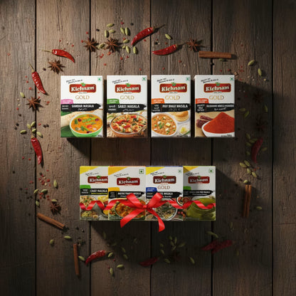 Kichanm Gold spice packs on a wooden background with spices and chilies.