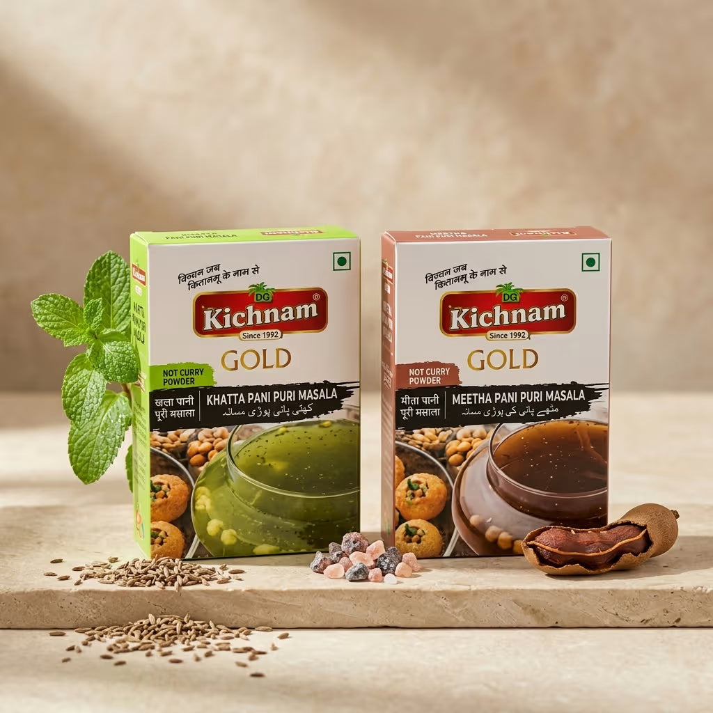 Two boxes of Kichnam Gold golgappa masala spices on a wooden surface with ingredients.